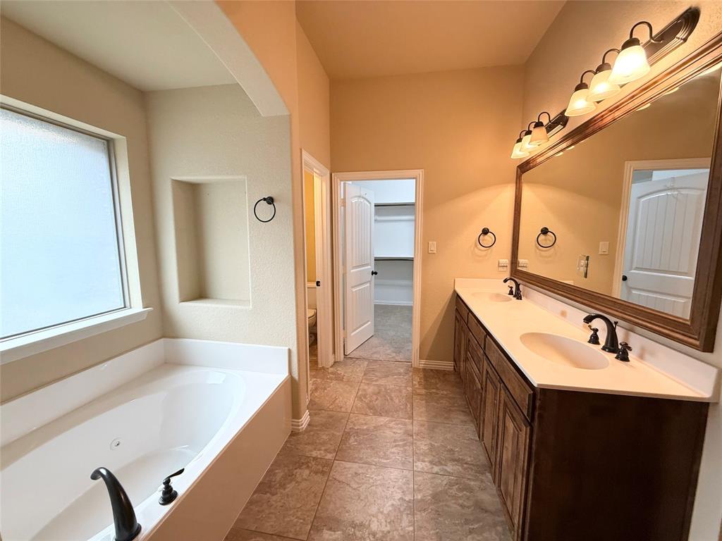 409 Corriente Trail Azle, TX 76020 - Photo 10 of 36 a spacious bathroom with a tub sink and mirror