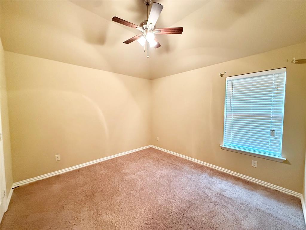 409 Corriente Trail Azle, TX 76020 - Photo 19 of 36 an empty room with a window and a ceiling fan