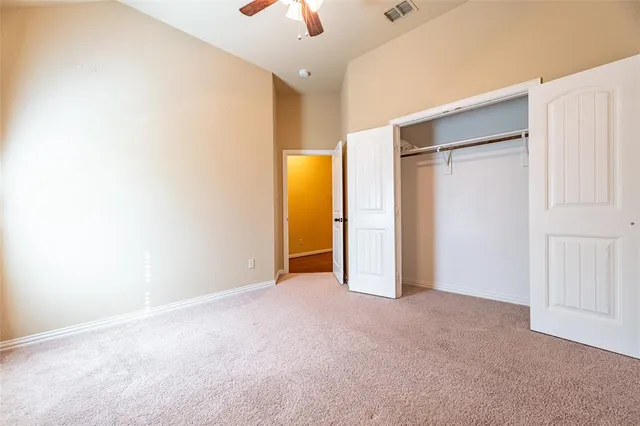 an empty room with a ceiling fan and wooden floor