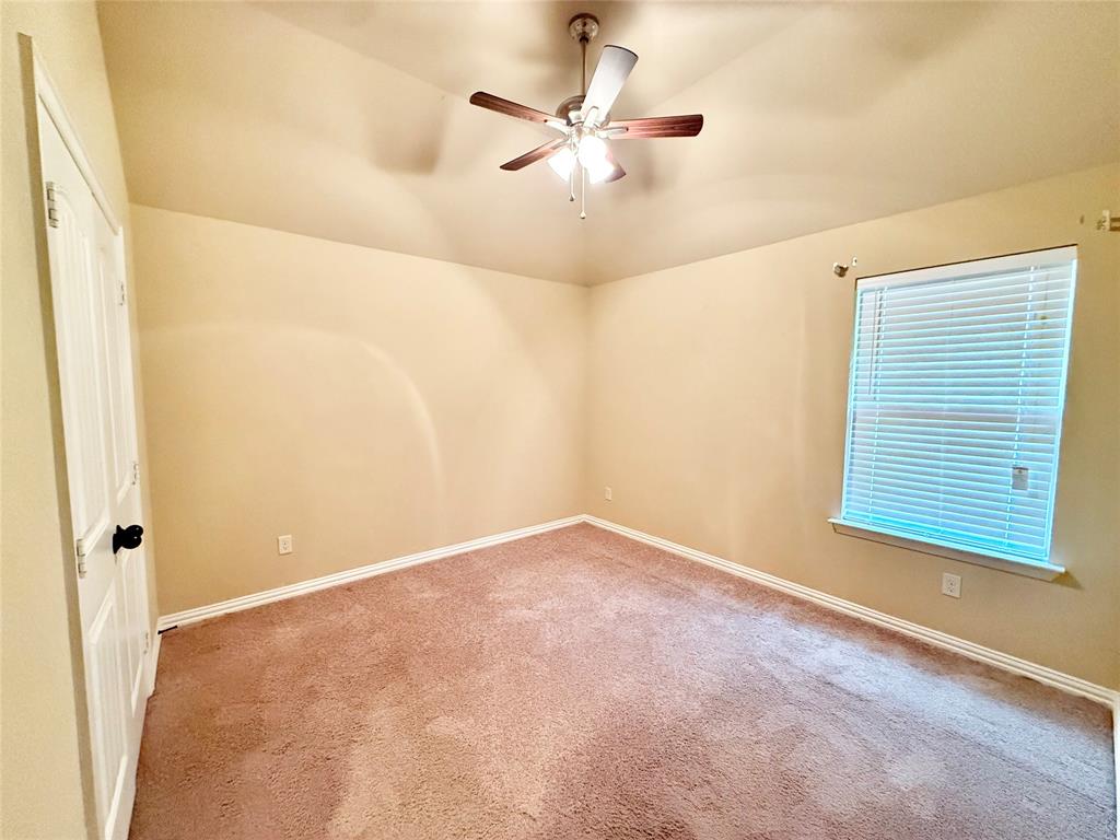 409 Corriente Trail Azle, TX 76020 - Photo 21 of 36 an empty room with a ceiling fan and a window