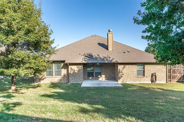 an aerial view of ocean and residential houses with outdoor space