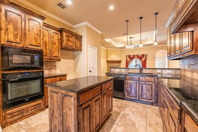 a kitchen with stainless steel appliances granite countertop a stove a sink and a microwave