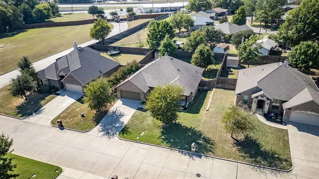 an aerial view of a residential houses with outdoor space and trees