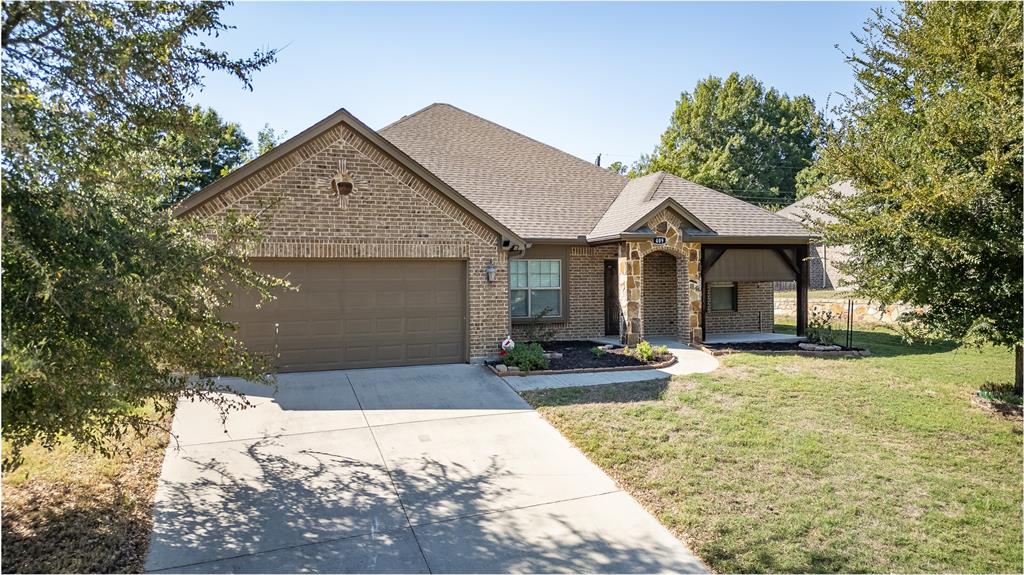 409 Corriente Trail Azle, TX 76020 - Photo 35 of 36 a front view of a house with a yard and garage