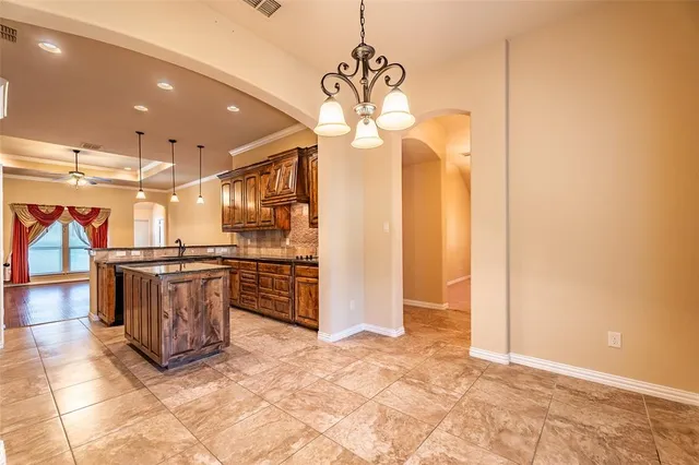 a view of a kitchen with stainless steel appliances granite countertop a stove a refrigerator a oven with a dining table and chairs