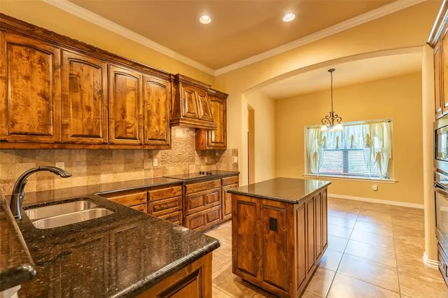 a kitchen with stainless steel appliances granite countertop a stove a sink and a microwave