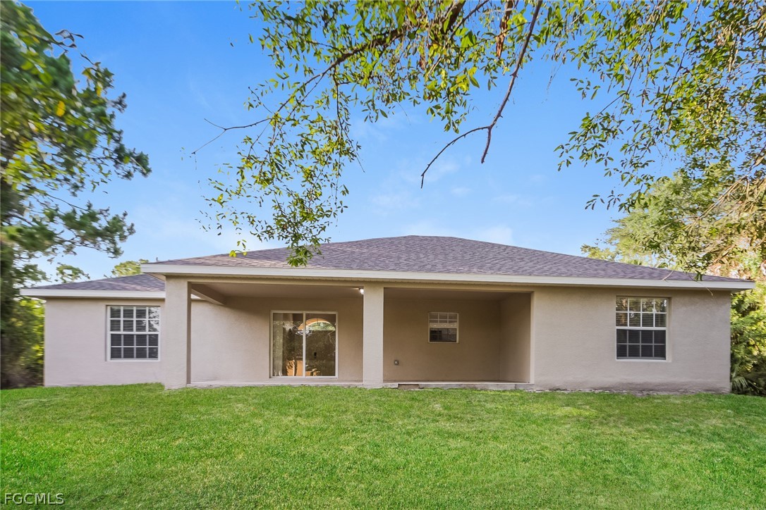 1018 Card Street East Lehigh Acres, FL 33974 - Photo 15 of 16 a front view of a house with a garden