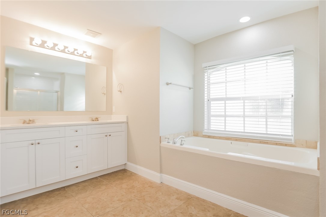1018 Card Street East Lehigh Acres, FL 33974 - Photo 10 of 16 a spacious bathroom with double vanity and a mirror