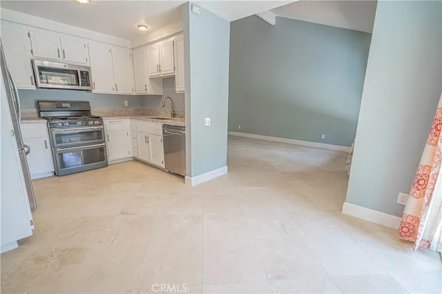 a kitchen with cabinets stainless steel appliances and a counter space