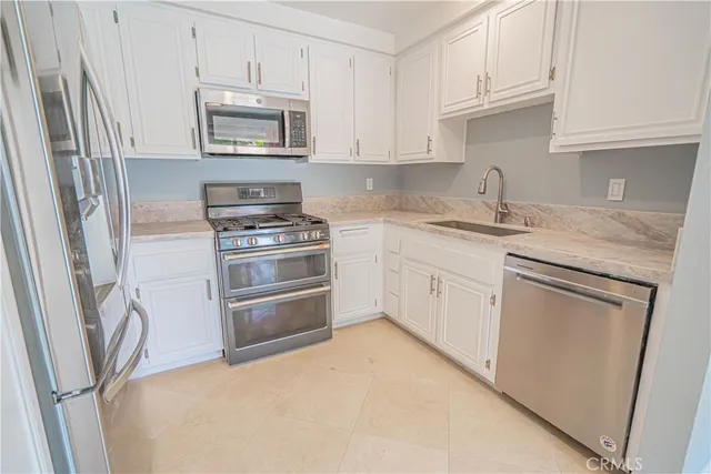 a kitchen with granite countertop white cabinets and a sink