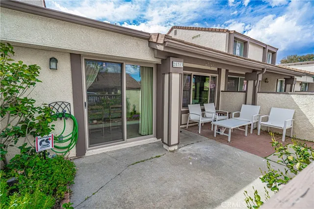 an aerial view of a tennis ground and a cars park side of the road