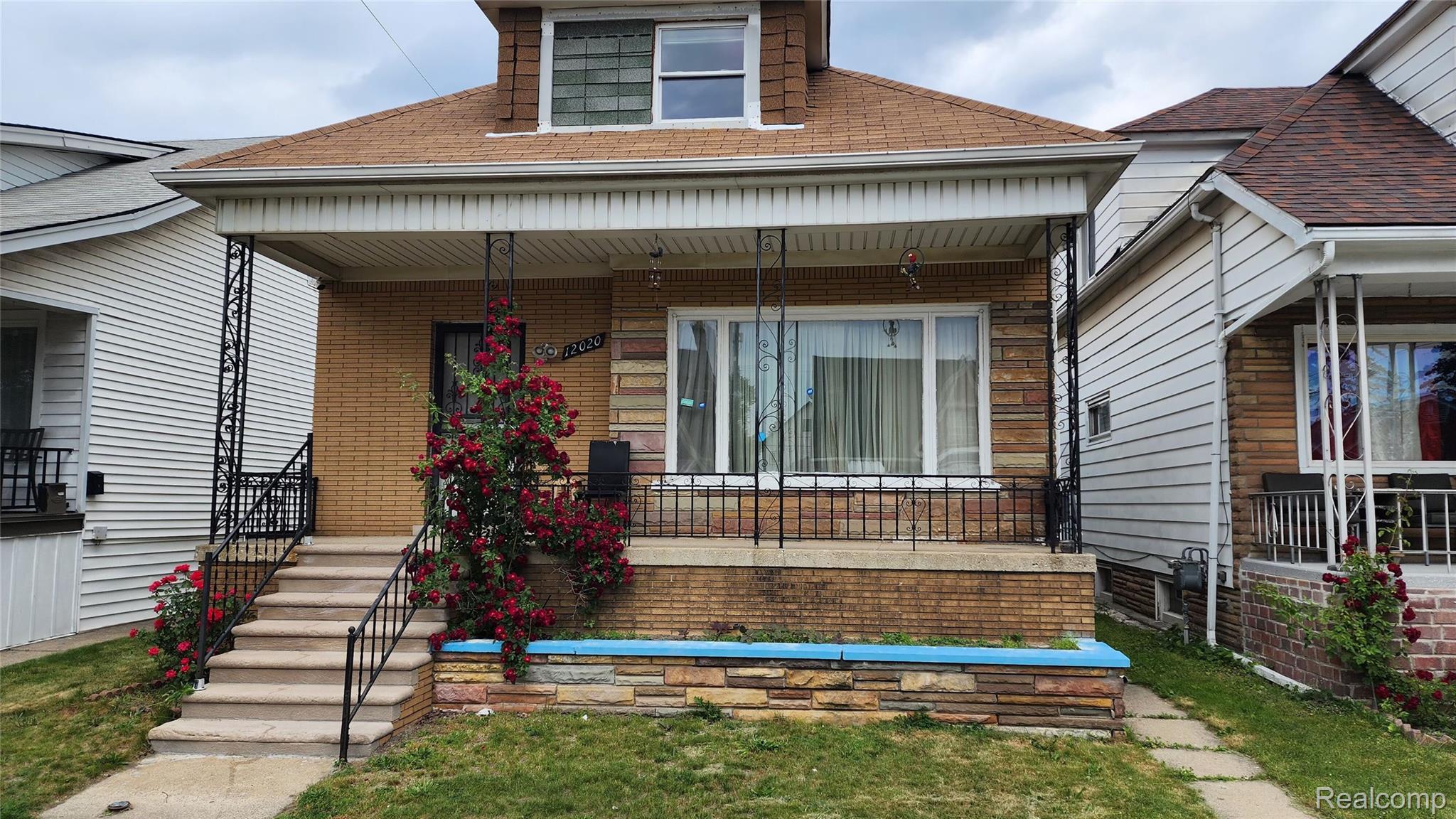 12020 Charest Street, Unit 2 Hamtramck, MI 48212 - Photo 3 of 21 Brick exterior featuring a covered porch with wrought iron columns and railing