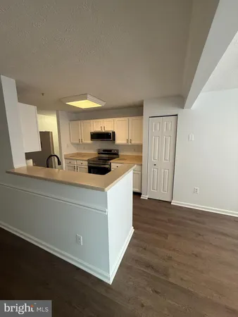 a kitchen with a refrigerator and a stove top oven