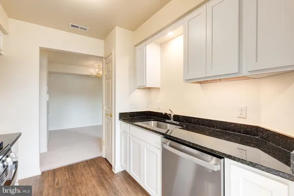 a kitchen with granite countertop a sink and a stove