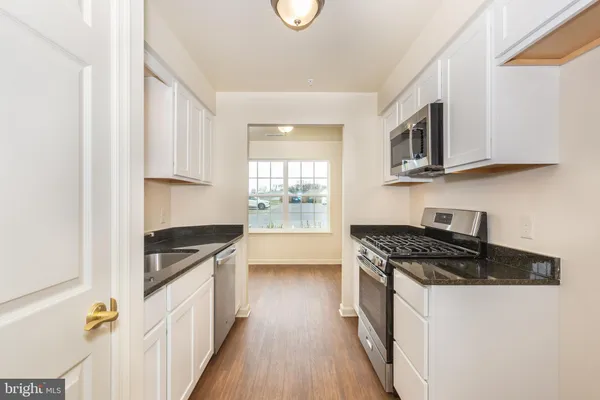 a kitchen with stainless steel appliances granite countertop a stove and a sink