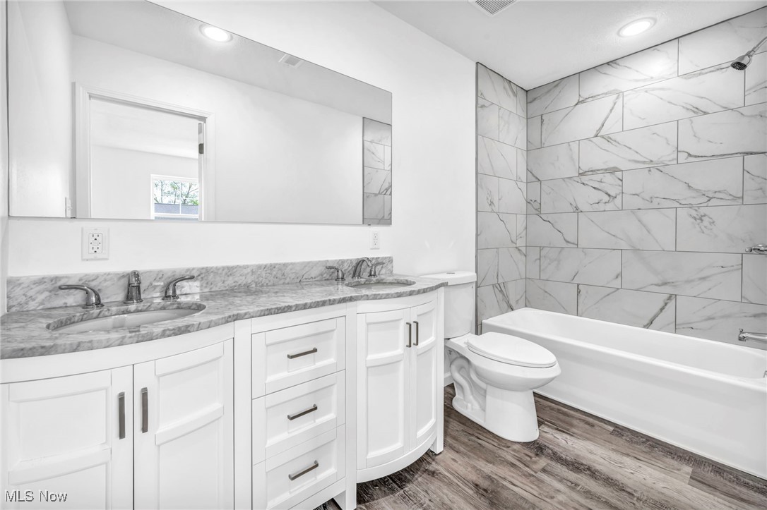 3709 Sudbury Road Cleveland, OH 44120 - Photo 17 of 29 Full bathroom with tiled shower / bath, vanity, toilet, and hardwood / wood-style floors