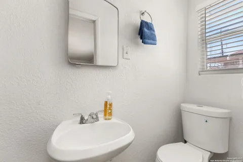 a bathroom with a toilet sink and mirror