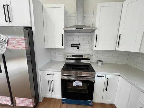 a kitchen with white cabinets and appliances