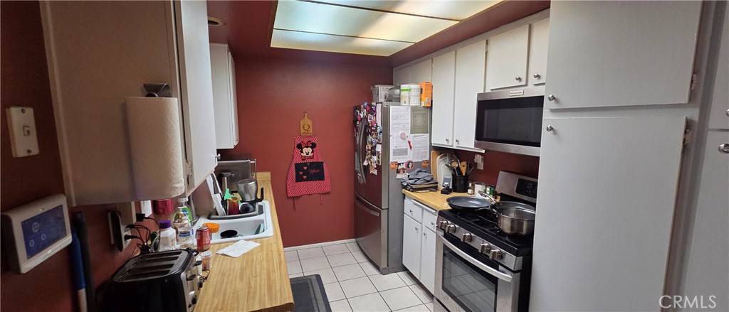 1548 Ranch Road San Bernardino, CA 92407 - Photo 9 of 26 a kitchen with stainless steel appliances a stove refrigerator and microwave