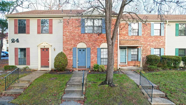 a front view of a house with a yard and potted plants