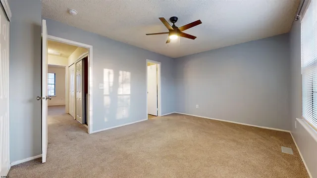 an empty room and chandelier fan