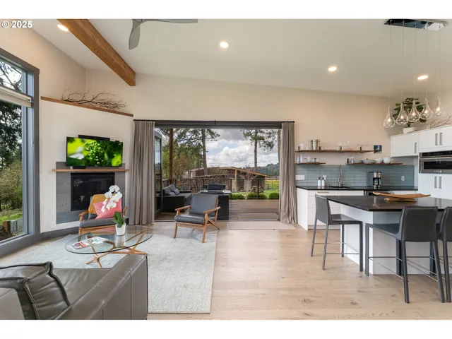 a living room with stainless steel appliances kitchen island granite countertop furniture and a wooden floor