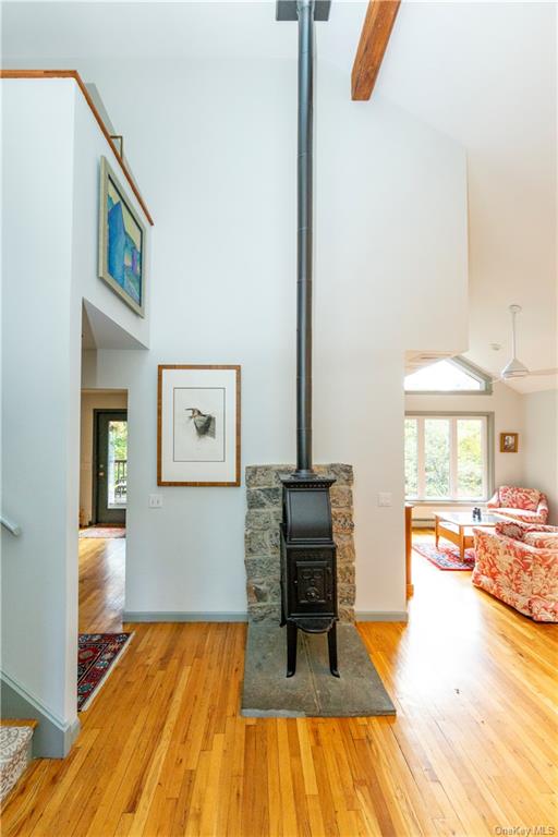 206 Quaker Hill Road Pawling, NY 12564 - Photo 11 of 36 Living room with a wood stove, light wood-type flooring, beamed ceiling, and plenty of natural light