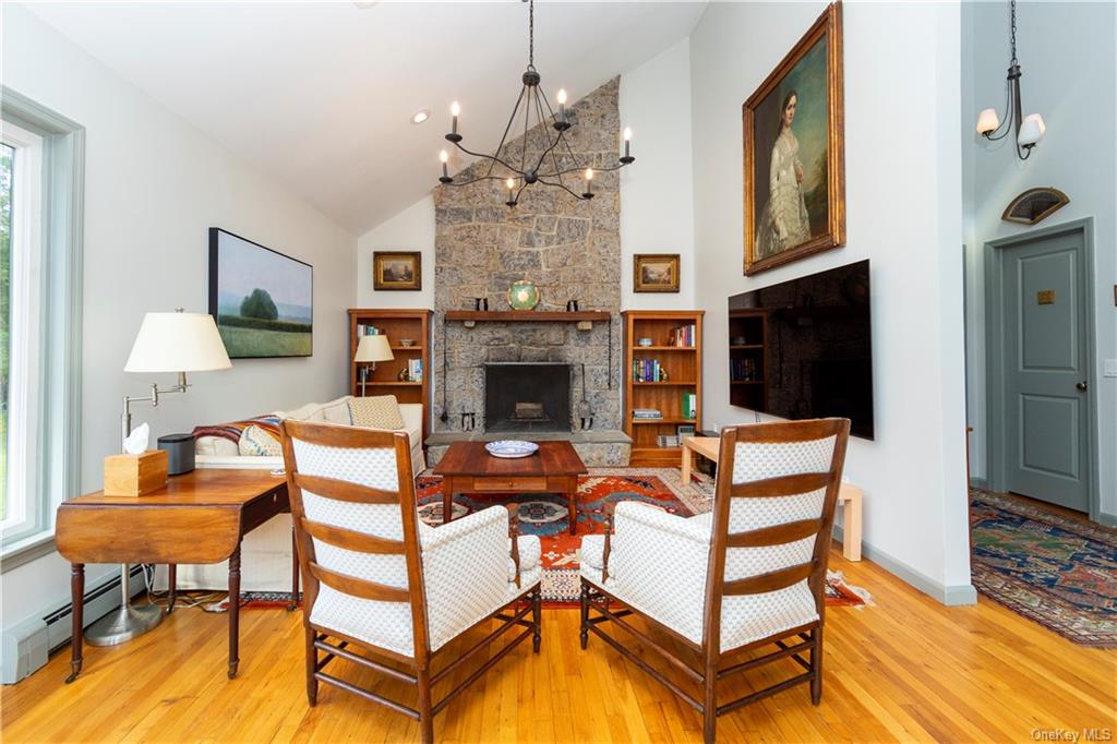 206 Quaker Hill Road Pawling, NY 12564 - Photo 14 of 36 Living room featuring a fireplace, a chandelier, and light hardwood / wood-style flooring