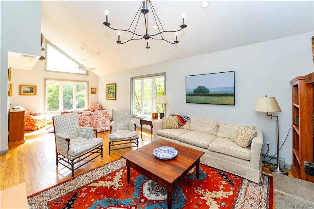 206 Quaker Hill Road Pawling, NY 12564 - Photo 15 of 36 Living room with ceiling fan with notable chandelier, lofted ceiling, and light hardwood / wood-style floors