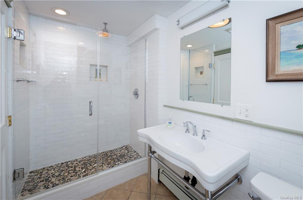 206 Quaker Hill Road Pawling, NY 12564 - Photo 33 of 36 Bathroom featuring tile walls, a shower with shower door, toilet, and tile patterned flooring