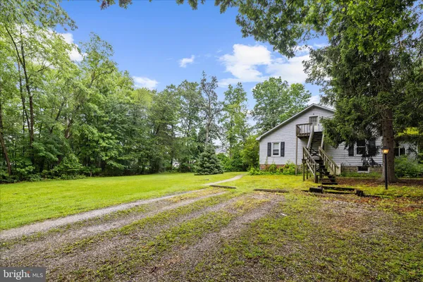 a view of a house with backyard and trees