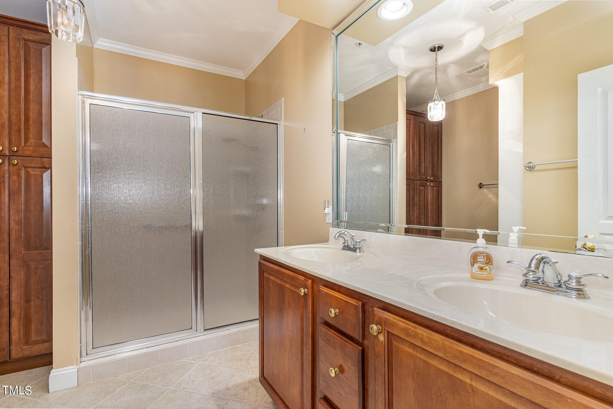 7510 Lead Mine Road, Unit 104 Raleigh, NC 27615 - Photo 13 of 23 Primary bathroom with double sinks, large shower and custom cabinets and shelving for added storage, linens, toiletries
