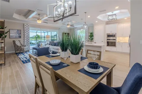 a view of a dining room with furniture a chandelier and wooden floor