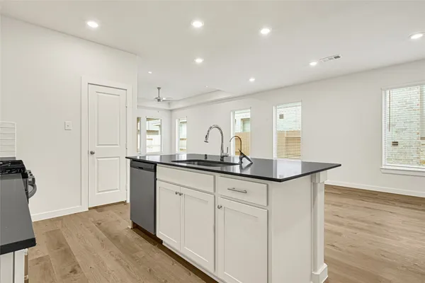 a kitchen with granite countertop a sink and a stove top oven
