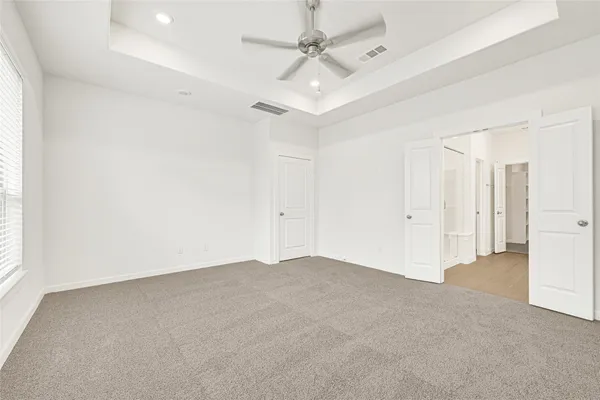 an empty room with a ceiling fan and a window