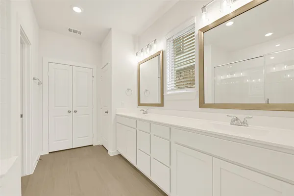 a bathroom with a double vanity sink and a mirror