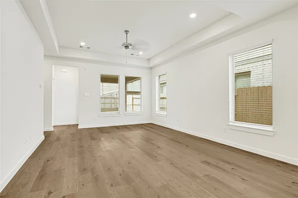 an empty room with wooden floor and windows