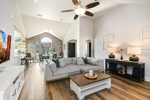 a dining room with furniture a chandelier and wooden floor