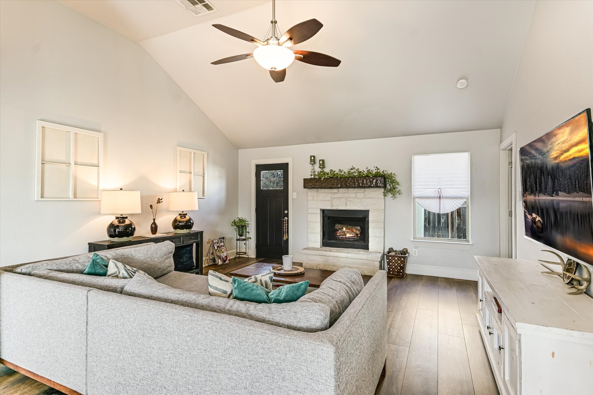 18516 Champions Circle Lago Vista, TX 78645 - Photo 4 of 30 a living room with furniture a flat screen tv and a fireplace