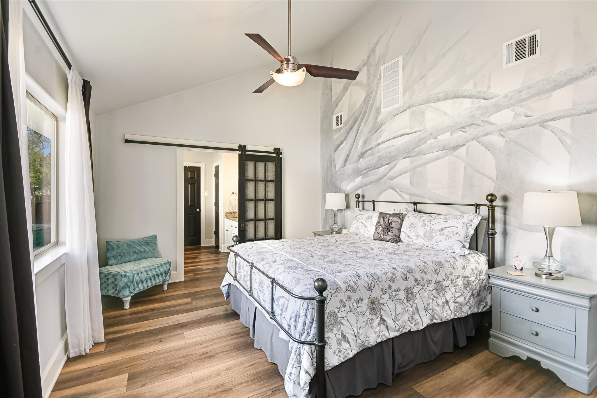 18516 Champions Circle Lago Vista, TX 78645 - Photo 5 of 30 a bedroom with a large bed and a chandelier