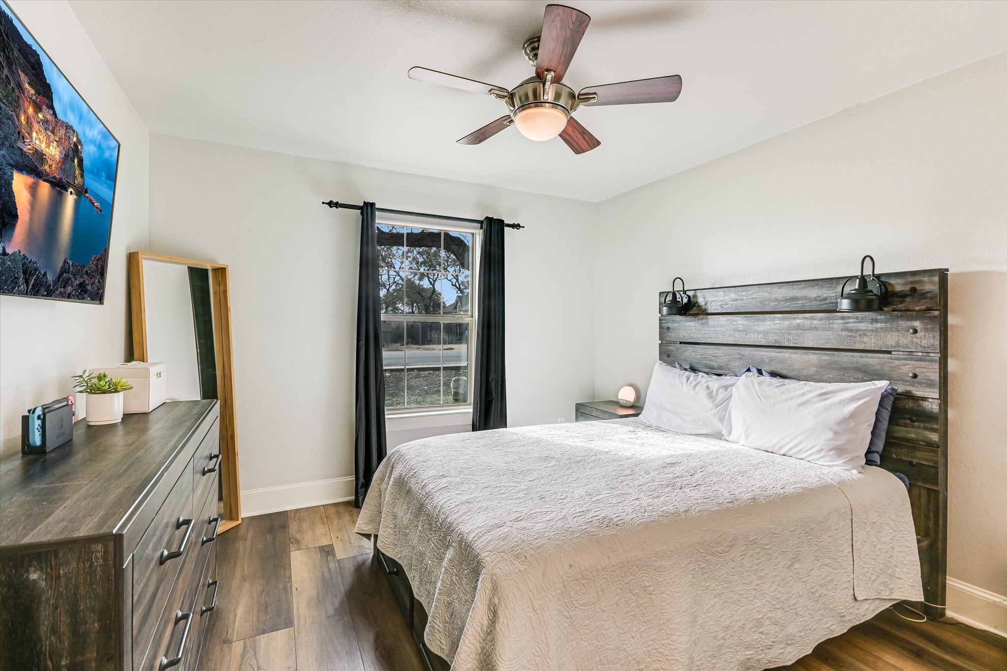 18516 Champions Circle Lago Vista, TX 78645 - Photo 9 of 30 a bedroom with a bed and a chandelier