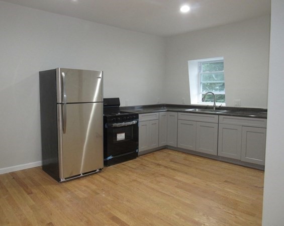 311-313 Providence Road Grafton, MA 01560 - Photo 9 of 21 a kitchen with stainless steel appliances granite countertop a refrigerator a sink a stove with wooden floor