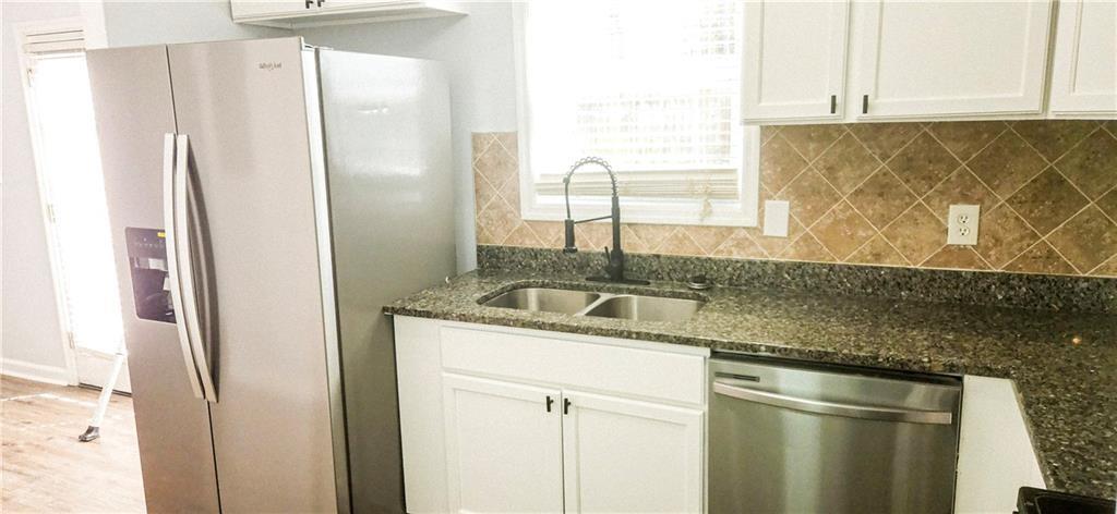 5582 Windwood Road Atlanta, GA 30349 - Photo 12 of 29 a kitchen with stainless steel appliances granite countertop a refrigerator and a sink