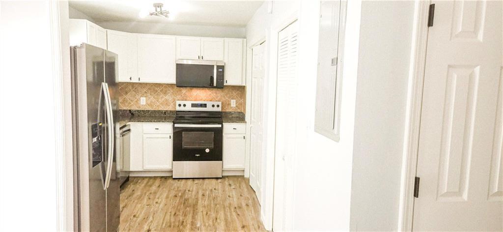 5582 Windwood Road Atlanta, GA 30349 - Photo 9 of 29 a kitchen with stainless steel appliances granite countertop a stove and a refrigerator