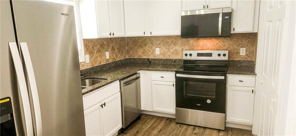 5582 Windwood Road Atlanta, GA 30349 - Photo 10 of 29 a kitchen with stainless steel appliances a stove microwave and refrigerator