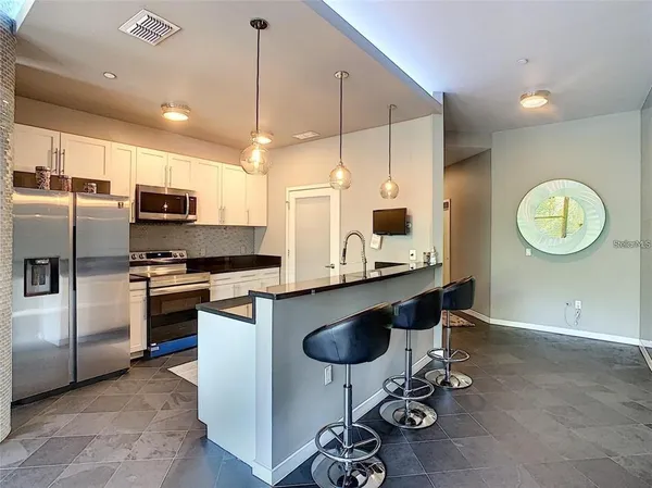 a kitchen with kitchen island granite countertop a stove cabinets and a refrigerator