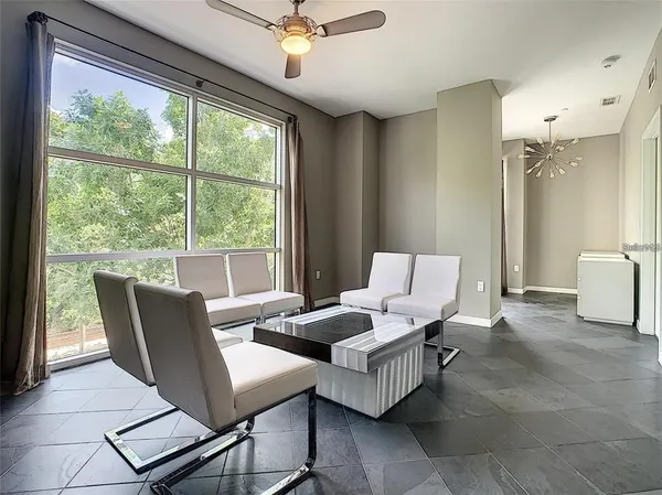 a living room with furniture and floor to ceiling windows