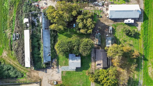 an aerial view of residential house with outdoor space and trees all around