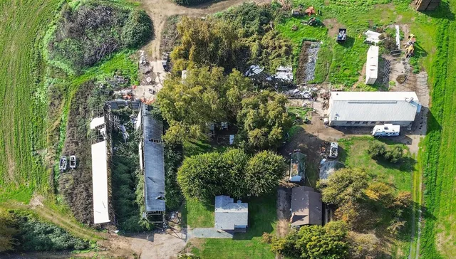 an aerial view of residential house with outdoor space and trees all around
