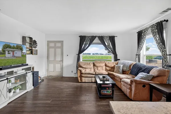 a living room with furniture and a wooden floor